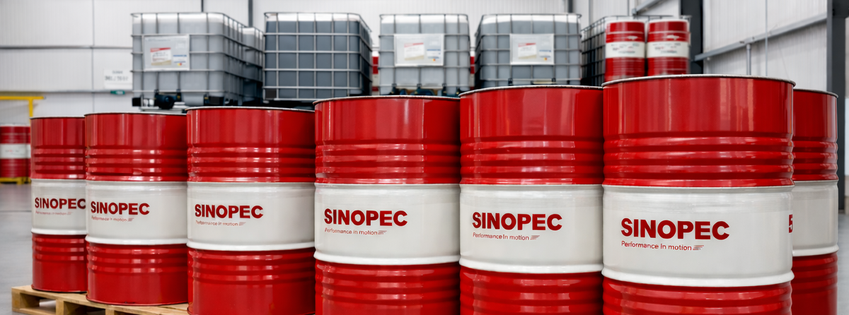 Red Sinopec barrels on wooden pallets in a warehouse setting